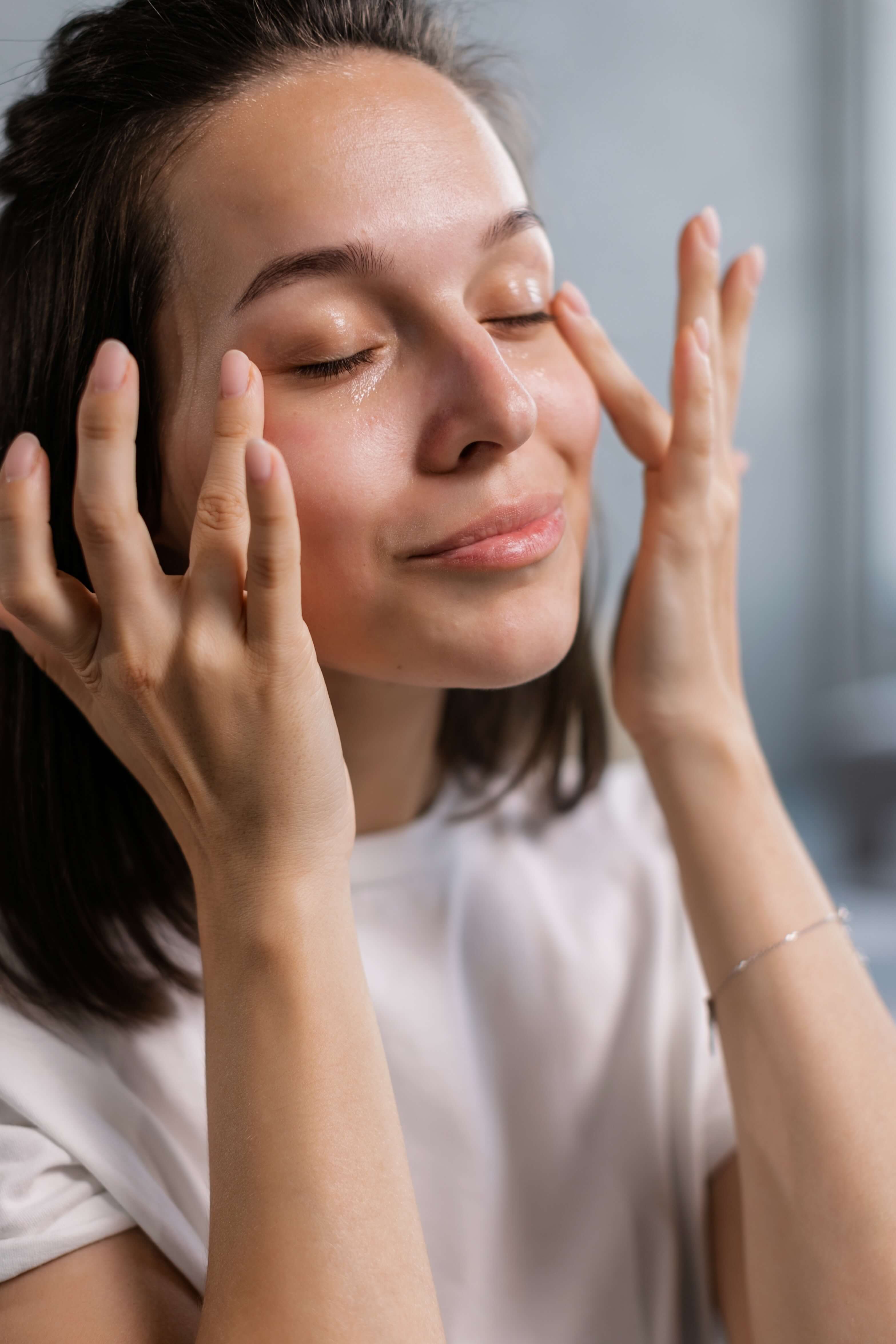 Mulher tocando o rostocom os olhos fechados